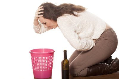 喝酒太多的女人，爬在垃圾桶边呕吐的图片