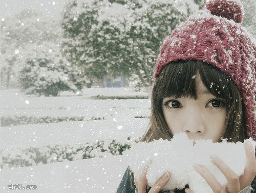 在雪地里用手捧雪玩的女生