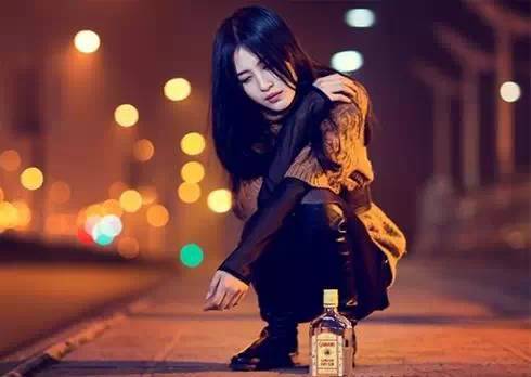 失恋的女人在马路上借酒浇愁