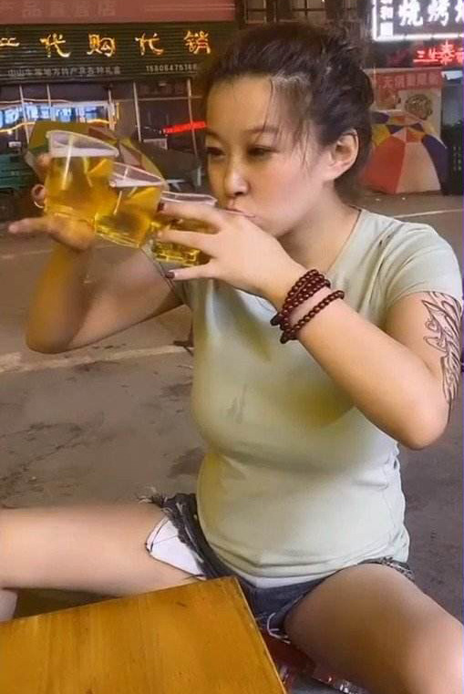 在路边三杯连饮的纹身女子