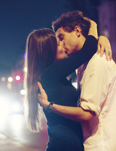 情侣在夜色中的大街上热吻