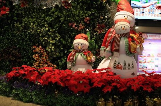 花丛中三个可爱的圣诞小雪人