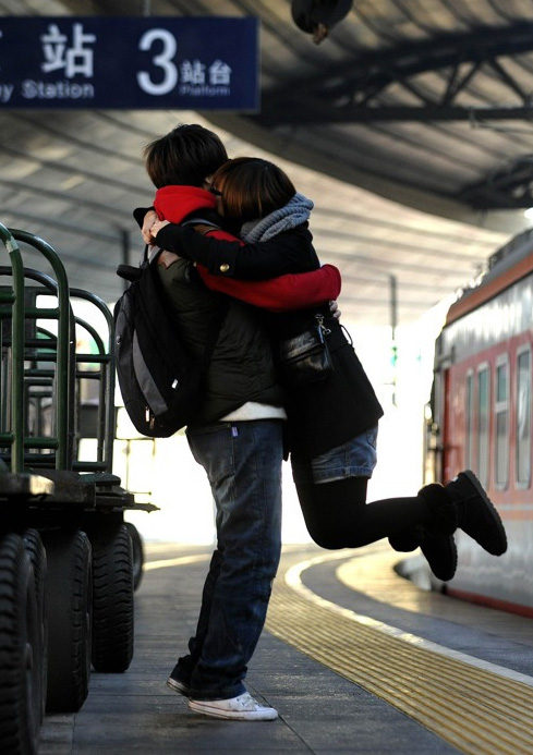 情侣在站台上亲密抱抱的图片