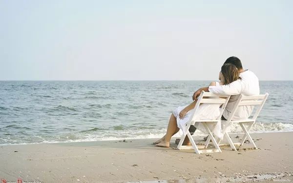 一起坐在沙滩上吹海风的幸福情侣图片